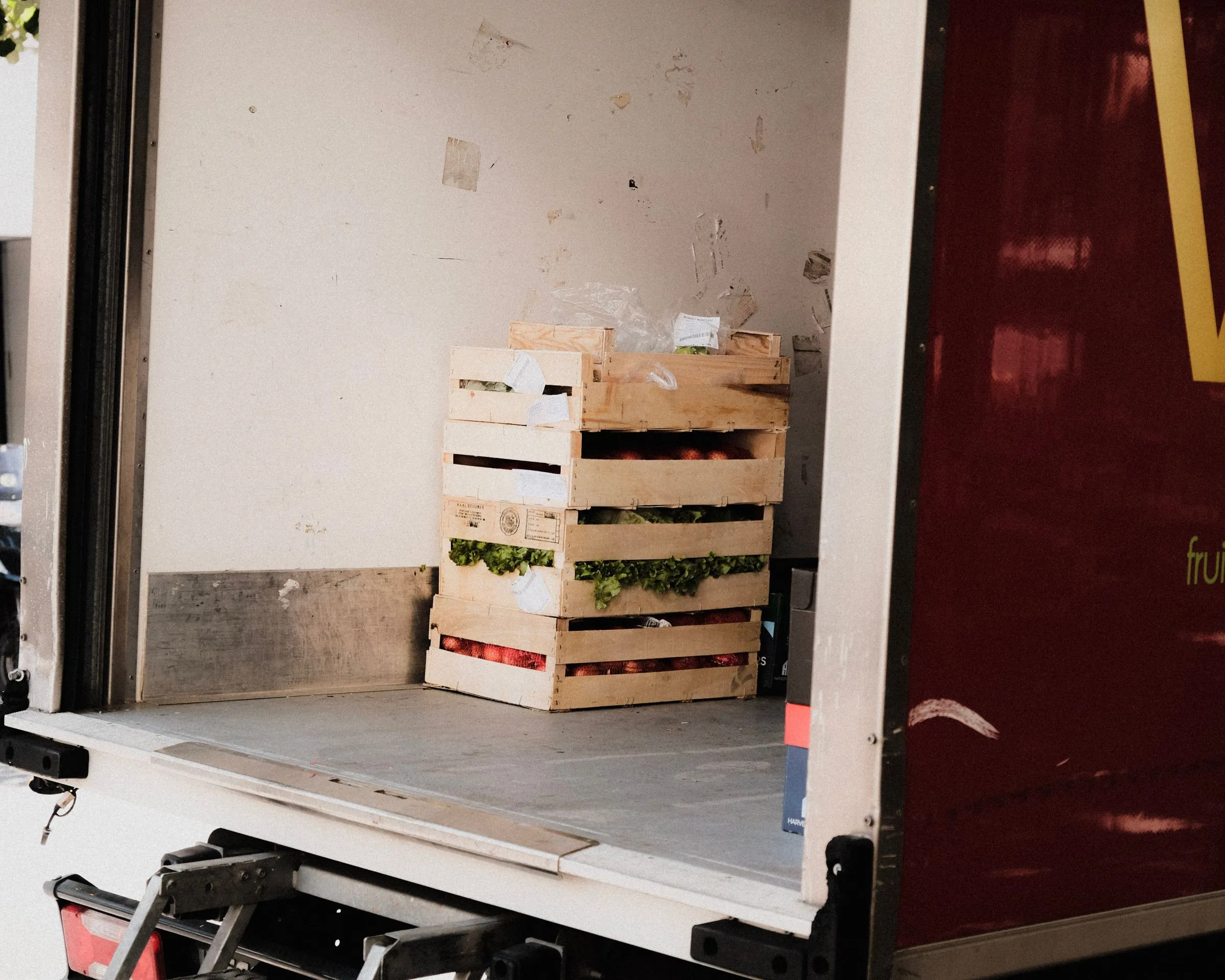Wooden crates of produce stacked in the back of a van